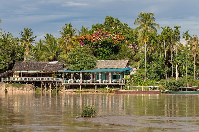 Thatched wooden stilt cabins and walkway over water at Baimuru Fishing Lodge